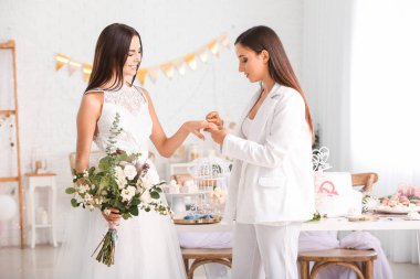 Genç lezbiyen çift düğün töreni sırasında yüzük alışverişi