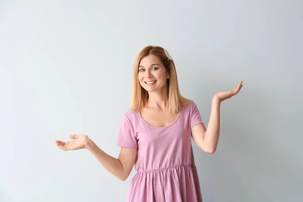 Beautiful woman holding something on light background