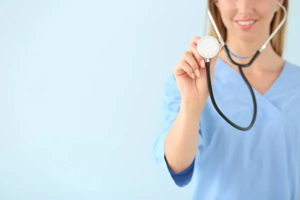 色の背景に聴診器を持つ女性看護師 — ストック写真