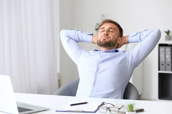 Handsome young man relaxing at workplace — Stock Photo, Image