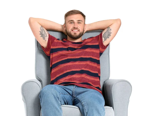 Handsome young man relaxing in armchair against white background — Stock Photo, Image