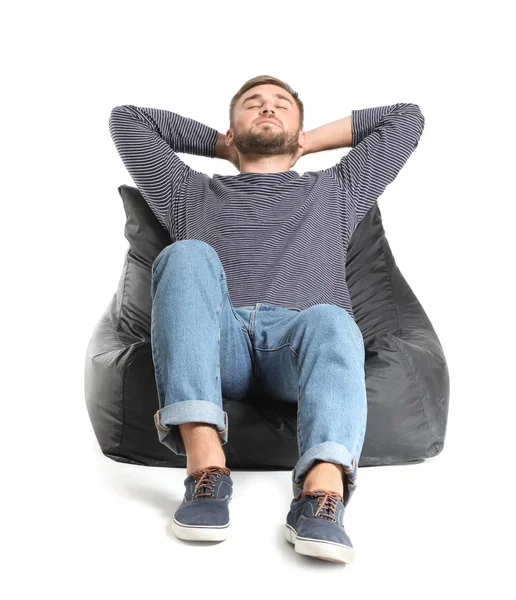 Przystojny młody człowiek relaks na beanbag na białym tle — Zdjęcie stockowe
