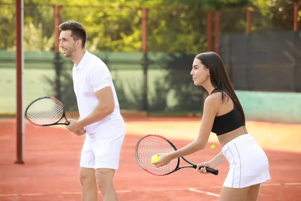 Młoda para, grając w tenisa na korcie — Zdjęcie stockowe