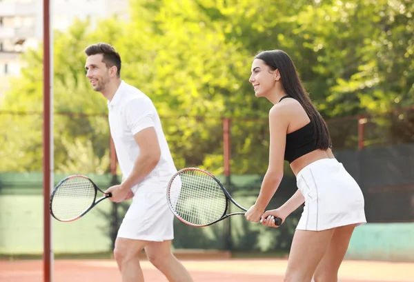 Young couple playing tennis on court — Stock Photo, Image