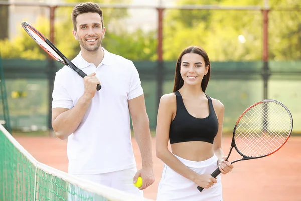 Young couple on tennis court — Stock Photo, Image
