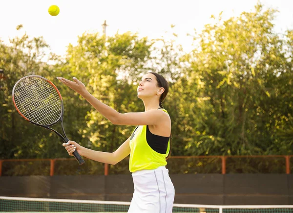Young woman playing tennis on court — Stock Photo, Image