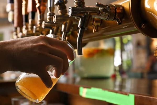 Barman versant de la bière fraîche dans du verre, gros plan — Photo