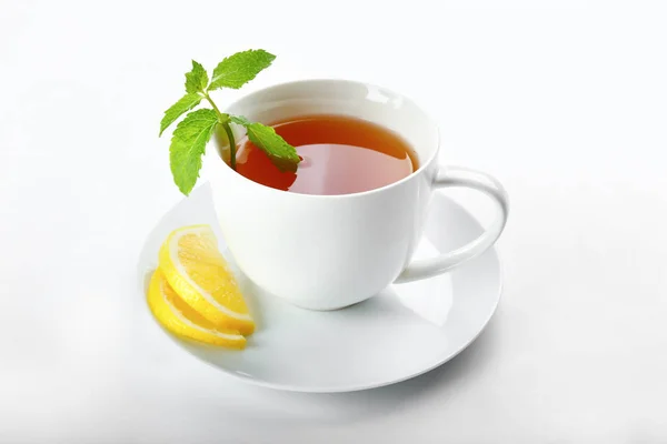 Cup of hot aromatic tea with lemon and mint on white background — Stock Photo, Image