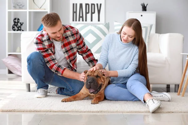 Happy couple with cute dog at home — Stock Photo, Image