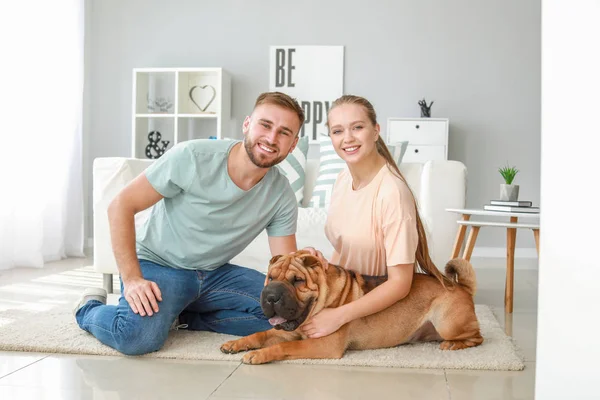 Happy couple with cute dog at home — Stock Photo, Image
