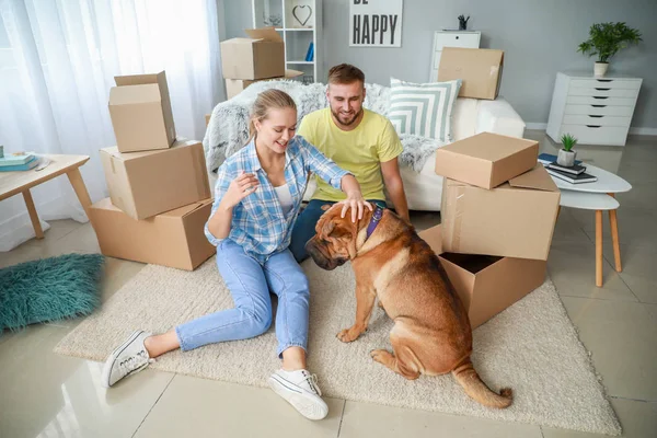 Happy couple with cute dog after moving into new house — Stock Photo, Image