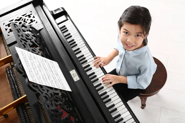 Klein meisje speelt vleugelpiano thuis — Stockfoto