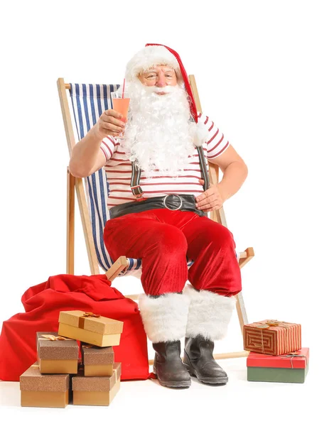 Papai Noel com presentes e coquetel sentado na cadeira de praia contra fundo branco — Fotografia de Stock