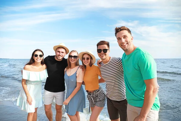 Happy friends on sea beach at resort