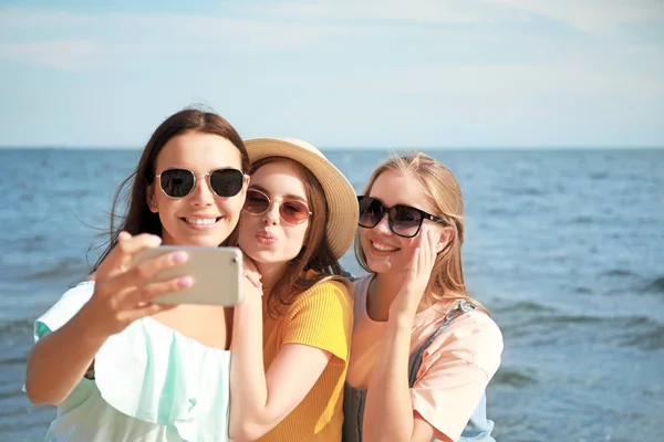 Joyeuses jeunes femmes prenant selfie sur la plage de la mer à la station balnéaire — Photo