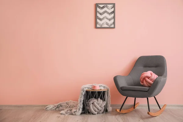 Stylowy fotel ze stołem w pobliżu kolorowej ściany w salonie — Zdjęcie stockowe
