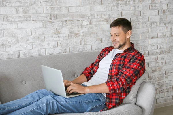 Людина з ноутбуком розслабляється вдома — стокове фото