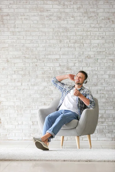 Człowiek ze słuchawkami i filiżanką herbaty relaksująca w domu — Zdjęcie stockowe