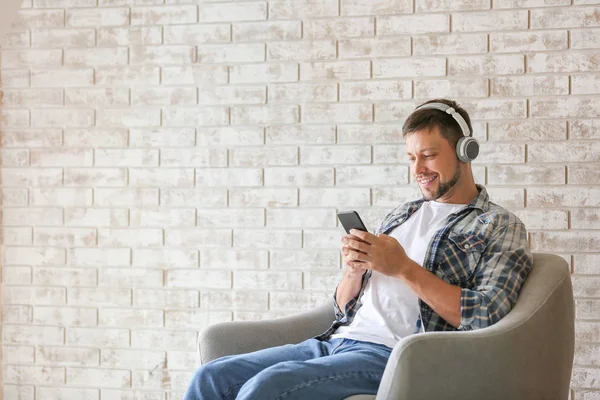 Man with mobile phone and headphones relaxing at home — Stock Photo, Image