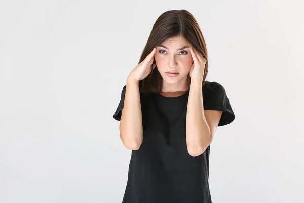 Stressato giovane donna su sfondo chiaro — Foto Stock