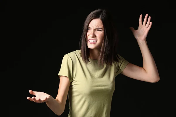 Stressed young woman on dark background — Stock Photo, Image