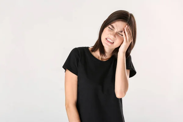 Stressed young woman on light background — Stock Photo, Image