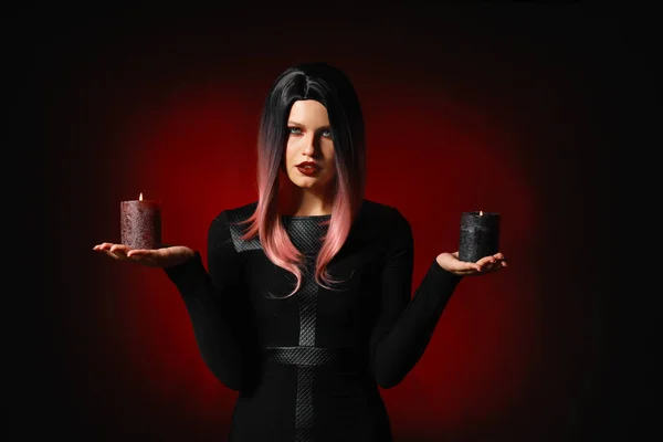Schöne Frau mit Kerzen zu Halloween auf dunklem Hintergrund — Stockfoto