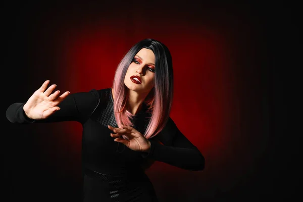 Schöne Frau zu Halloween auf dunklem Hintergrund gekleidet — Stockfoto