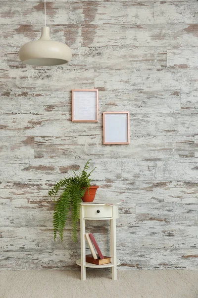 Table with houseplant near wooden wall — Stock Photo, Image