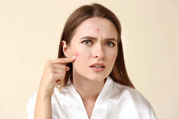 Portrait of young woman with acne problem on light background — Stock Photo, Image