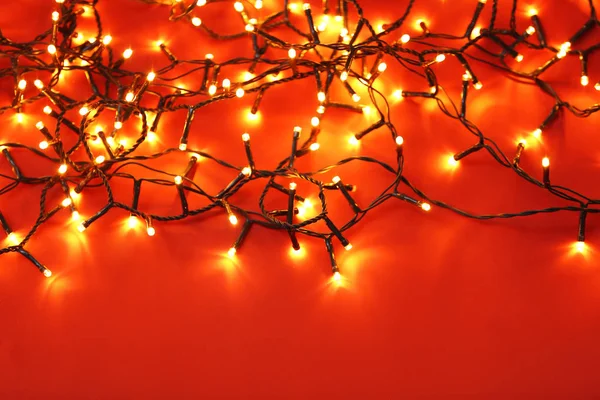 Красиві різдвяні вогні на кольоровому фоні — стокове фото