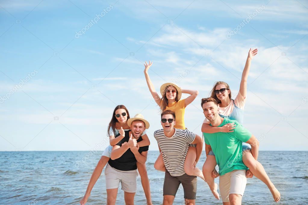 Happy friends on sea beach at resort