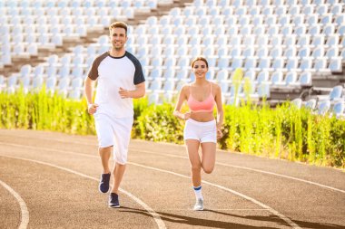 Sportif genç çift stadyumda çalışıyor