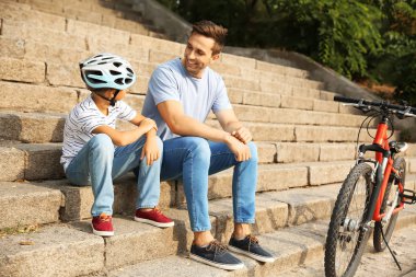 Mutlu baba ve oğlu bisiklet ile açık havada