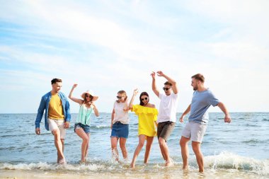 Tatil beldesinde deniz plajında eğlenen mutlu arkadaşlar