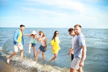 Tatil beldesinde deniz plajında eğlenen mutlu arkadaşlar