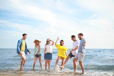 Tatil beldesinde deniz plajında eğlenen mutlu arkadaşlar