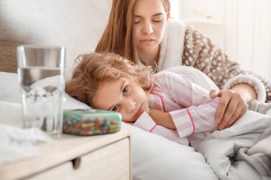 Anne evde grip olan küçük kızı ile ilgileniyor