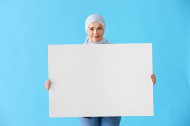 Renk arka plan üzerinde boş poster ile Güzel olgun Müslüman kadın