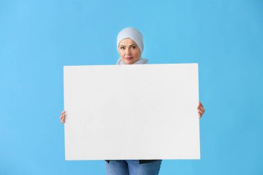 Renk arka plan üzerinde boş poster ile Güzel olgun Müslüman kadın