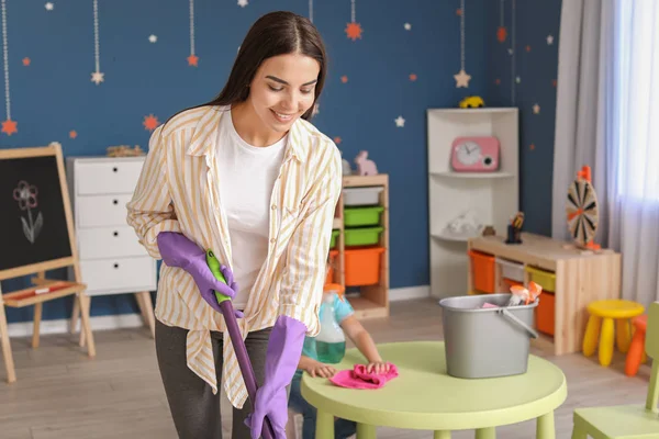 Młoda kobieta sprzątanie pokoju dziecka — Zdjęcie stockowe