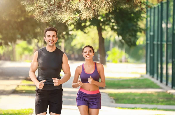 Deportiva joven pareja corriendo en parque — Foto de Stock