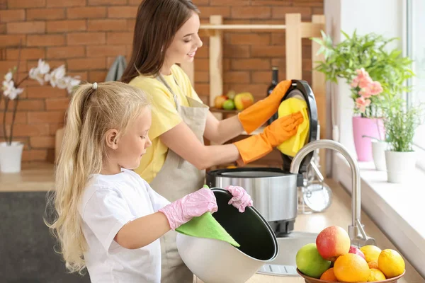 Woman and her little daughter washing multi cooker in kitchen — Stock Photo, Image