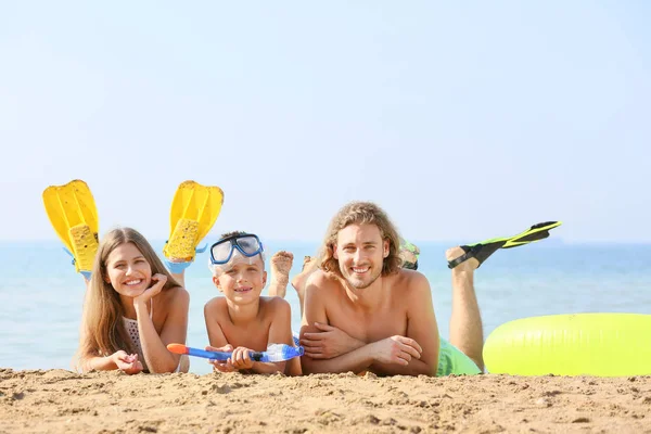 Familia feliz descansando en la playa del mar — Foto de Stock