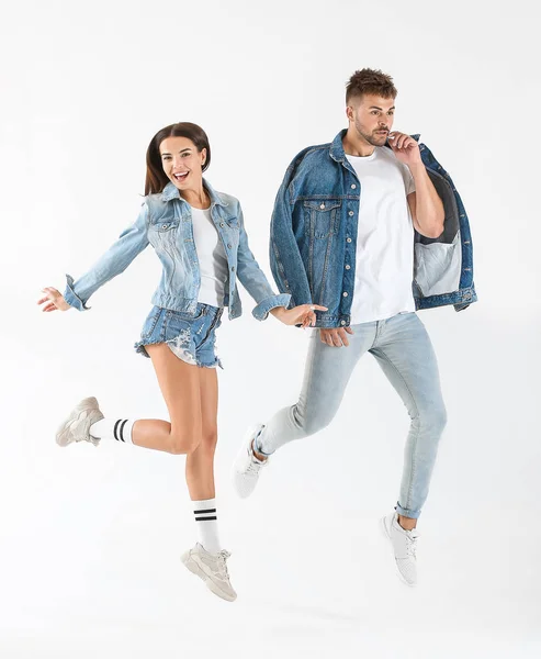 Fashionable jumping young couple on white background — Stock Photo, Image