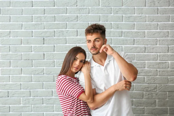 Jeune couple à la mode contre un mur de briques — Photo
