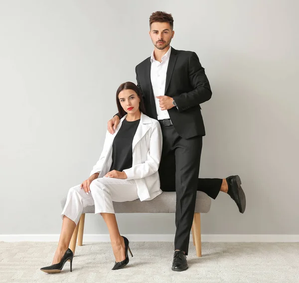 Stylish young couple near white wall — Stock Photo, Image