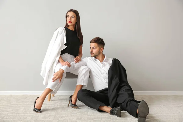 Stylish young couple near white wall — Stock Photo, Image