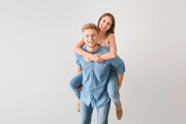 Jovem casal em roupas casuais elegantes no fundo claro — Fotografia de Stock