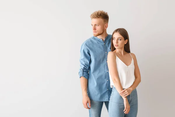 Young couple in stylish casual clothes on light background — Stock Photo, Image